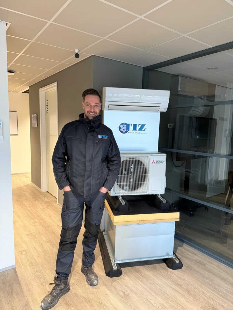 Tim, medewerker van TIZ, bij de demo-opstelling met Mitsubishi Electric binnen- en buitenunit